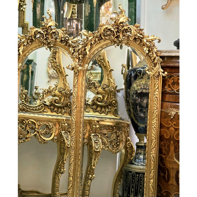 Elevate your interior with this striking French-inspired wall mirror, featuring an elaborate gold leaf frame crowned with...