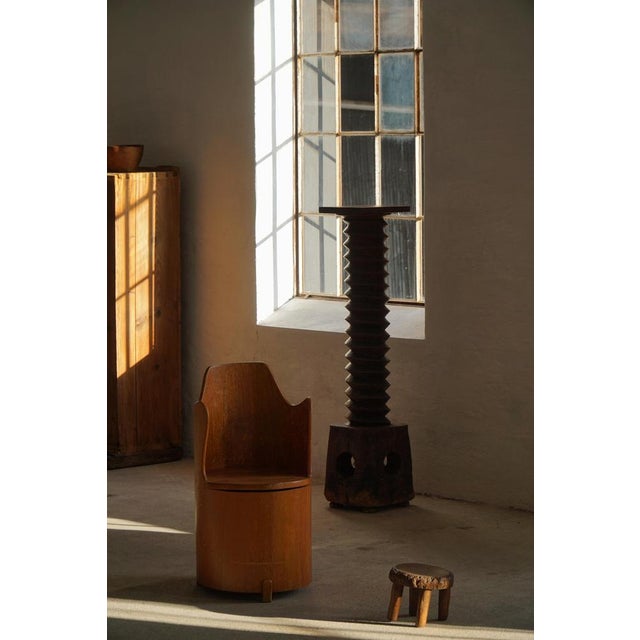 A fine example of a mid 20th-century Swedish Stump Chair, "Kubstol", crafted in pine with a sculptural silhouette and...