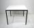 A satin black steel T Angle framed extension dining table with white Laminate top having a pop up folding leaf which...