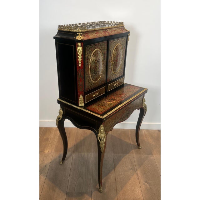 This magnificent Bonheur du Jour desk is made of Boulle marquetry. The upper part is stepped, opening with two medallion...