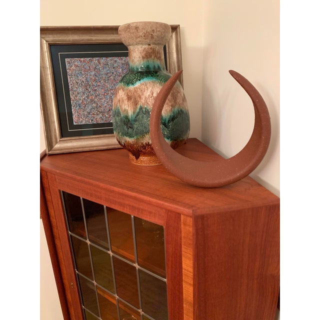 Gorgeous red stoneware standing sculpture in a crescent moon shape by Claremont, CA artist T. Pacini. Built in stand so it...