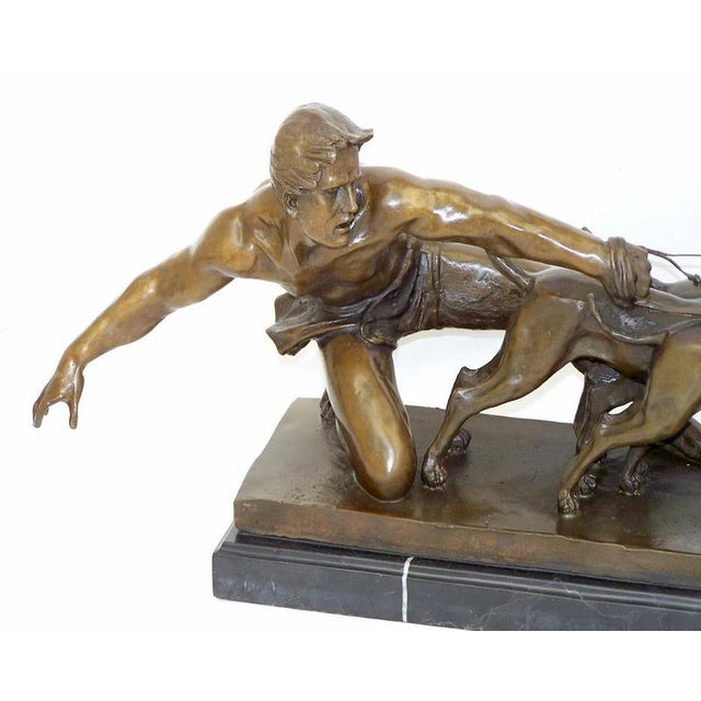 Art Deco style bronze figurine depicting a dynamic scene of a male figure controlling a team of running dogs. Cast in...