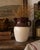 This handsome vintage American pottery pitcher features a classic two-tone glazed finish with a rich chocolate brown upper...