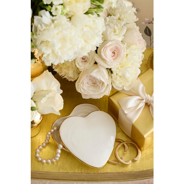 This lidded ceramic box is crafted in the shape of a heart with an artisanal ribbed texture and is enhanced with gold...