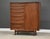 A mid century modern teak armoire dresser with seventeen dovetail drawers and sliding tambour door by Falster....