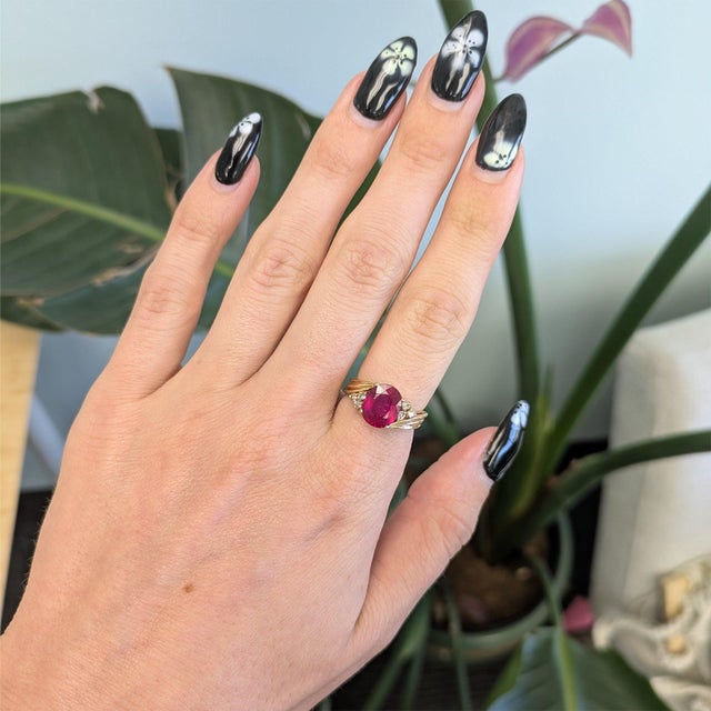 A 4.42-carat Madagascar ruby glows in a deep, warm red at the center of this solid 14K yellow gold estate ring, accented...