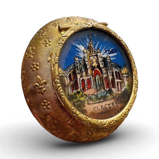 A jewel from the dawn of the electric age, this diminutive round gilded box was created as a luxury souvenir for the Paris...