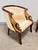 A pair of Maitland-Smith empire bergère chairs in parcel gilt with hand-carved swan-neck armrests and silk grosgrain...