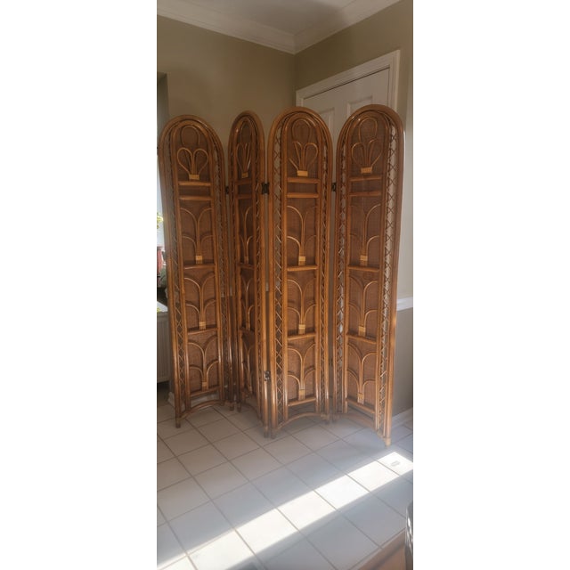 1990's Italian four-panel room divider crafted from natural rattan and woven caning. Featuring arched tops, decorative...