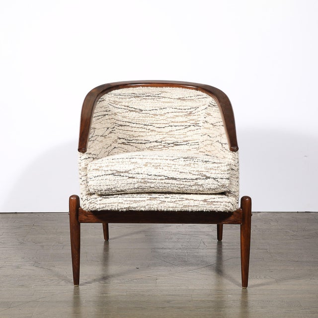 A stunning Mid-Century Modernist tub back club chair, crafted in rich walnut, featuring sleek tapered sculptural supports,...