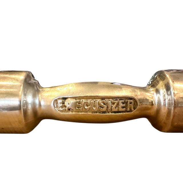 A quirky, brass dumbell paper weight. Features solid,, brass construction with the words “Execusizer’ engraved on the...