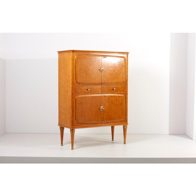 Italian Cabinet in Birdseye Maple, 1950s and mirrored interior and inside lighting. The shapes and form language so as the...