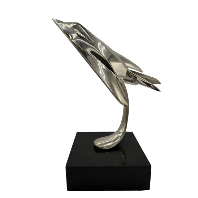 Striking chrome-plated steel sculpture of the famous Lockheed F-117 Nighthawk stealth jet fixed to a black onyx-colored...