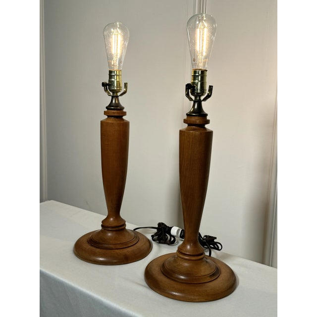 A classic traditional to neoclassical style shape and satin caramel fruitwood color finish compliment this pair of table...