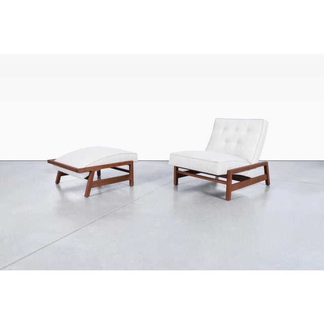 Mid-century modern walnut lounge chair and ottoman, handcrafted in the United States and styled after the celebrated...