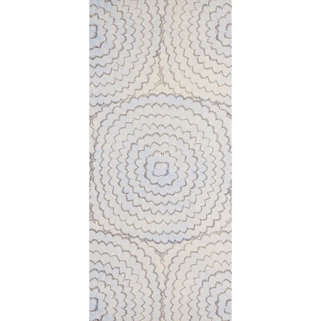 Overscale blossoms in a radiating pattern make a delicate and dreamy statement. The natural sisal ground adds dimension...