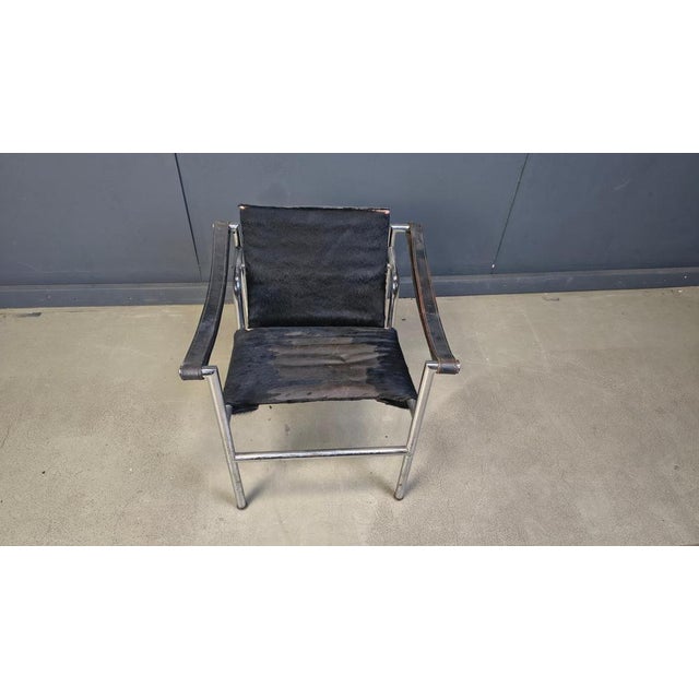 Vintage LC1 - armchair designed by Le corbusier with a chromed steel frame, ponyhide upholstery and leather armrests. The...