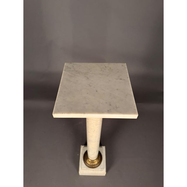 19th-century French pedestal or column crafted from Carrara marble and accented with decorative bronze mounts, dating to...