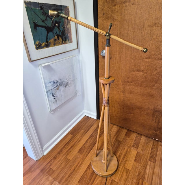 A real bamboo 1970s tripod lamp. It has some rattan wrapping in the middle of the lamp. Brass details. The lamp can rotate...