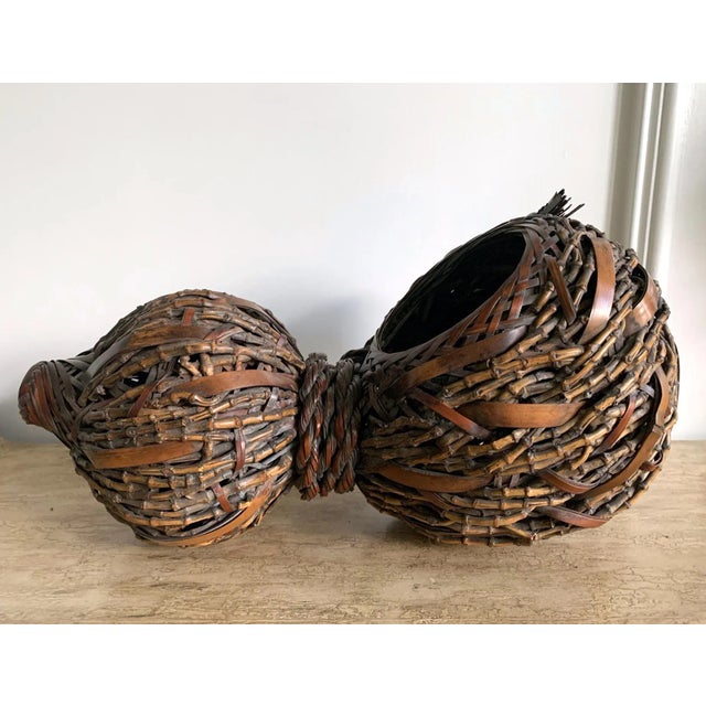 A lovely Japanese bamboo ikebana basket in the shape of gourd with an open mouth and a body circa 1920s-1940s. The piece...