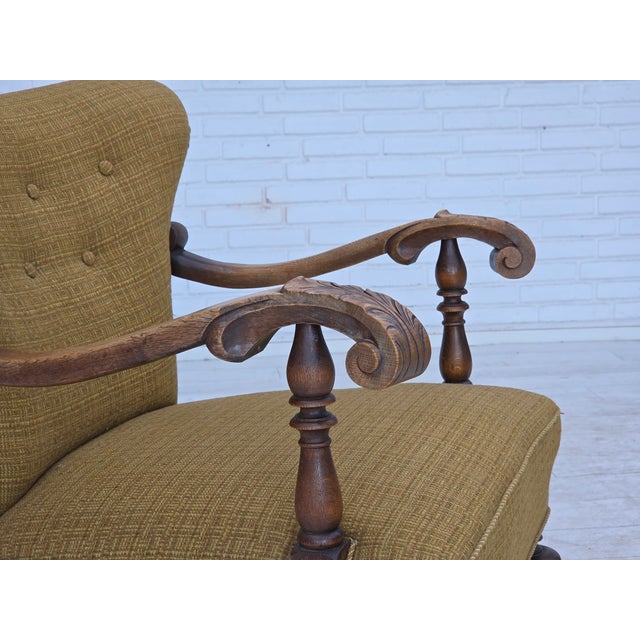 1960s, Danish armchair. Original green furniture wool, carved oak wood, brass springs in the seat. Original good...