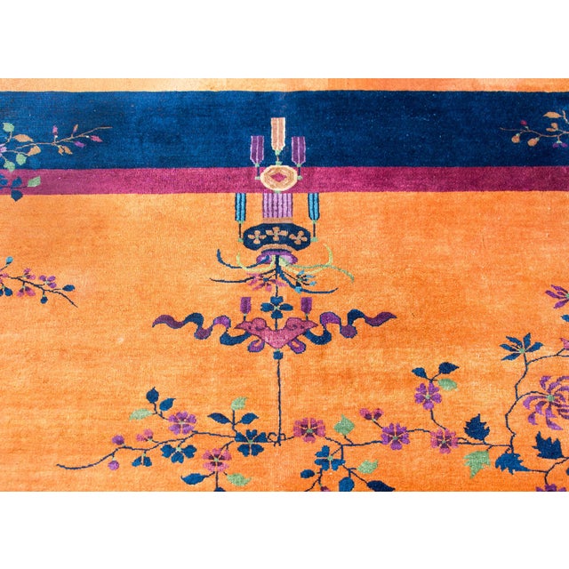A fantastic early 20th century Chinese Art Deco rug with a brilliant orange sherbet field surrounded by a thin violet...