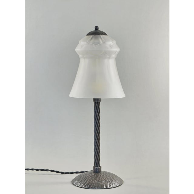 H. Fournet & Schneider A French art deco lamp in wrought iron. The forged base holds a rare model Schneider shade in...