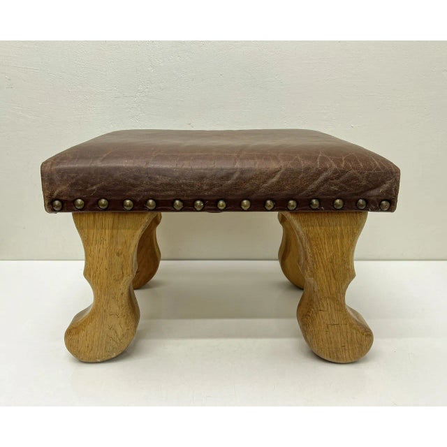 Vintage stool or footstool made of solid white oak with the original soft leather upholstery, finished with iron nails....
