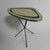 This table is also known as the "Expo 58" table. The tabletop features typical 1950s decoration and rests on crossed black...