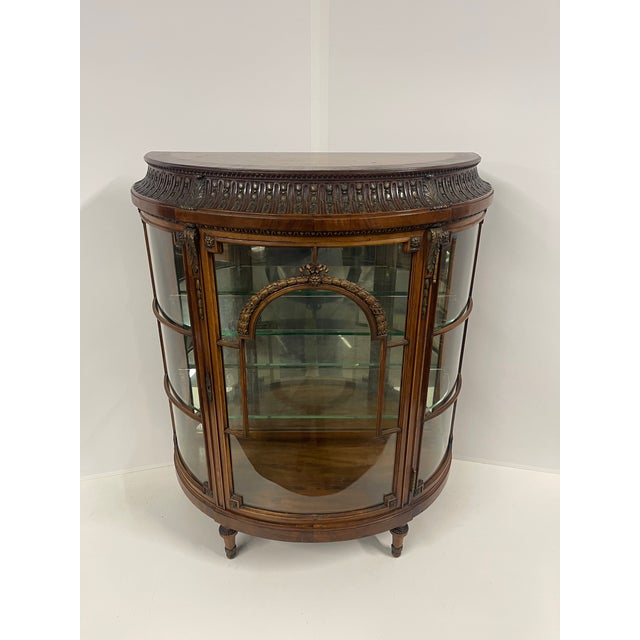 An antique demilune (half-round) French Louis XV walnut vitrine or curio display cabinet with a serpentine curved glass...