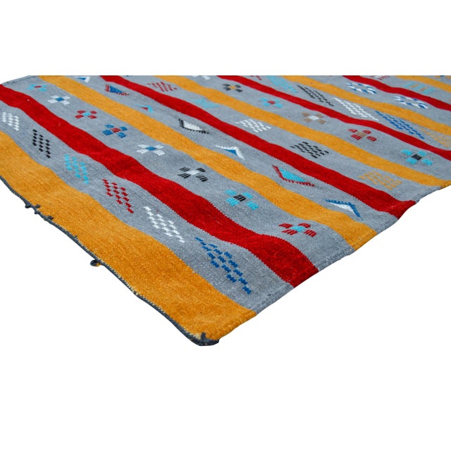 Handwoven Moroccan Berber kilim with geometric shapes, stripes and symbols of nature.