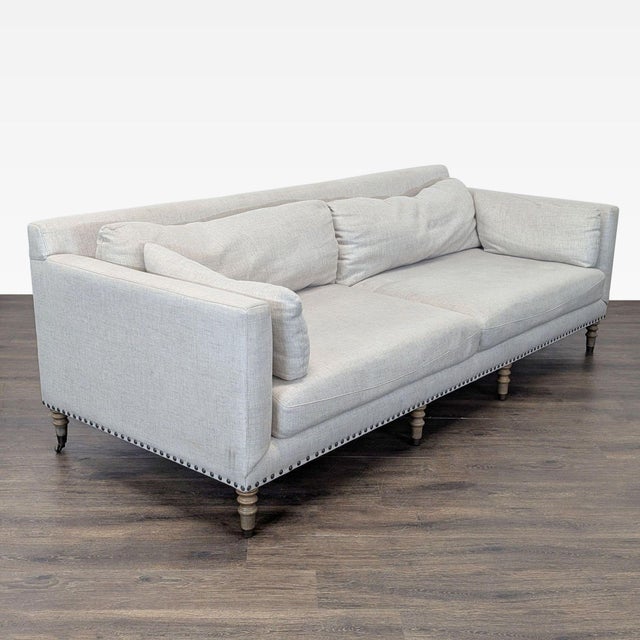 This Pottery Barn 3-seat sofa features a stylish neutral fabric and classic wooden legs. It includes two large seat...