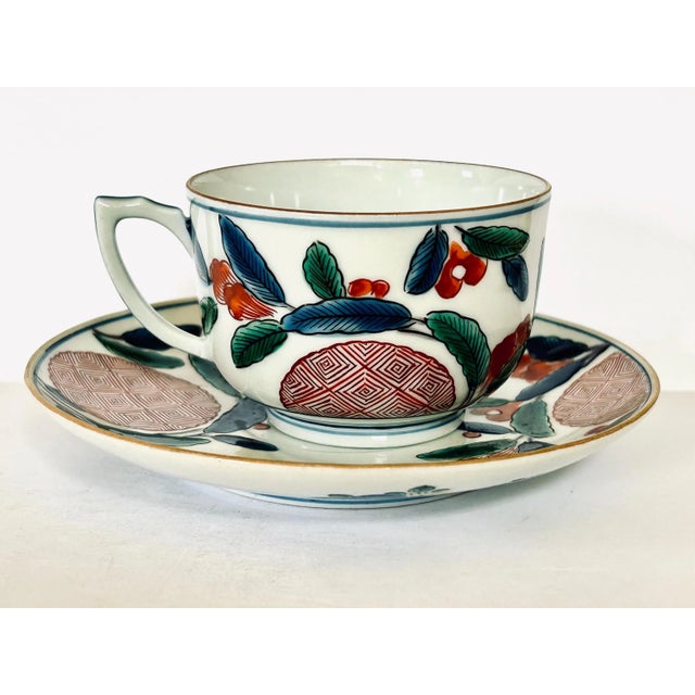 Japanese Arita porcelain cup and saucer set featuring traditional Imari ware decoration, characterized by its hand-painted...