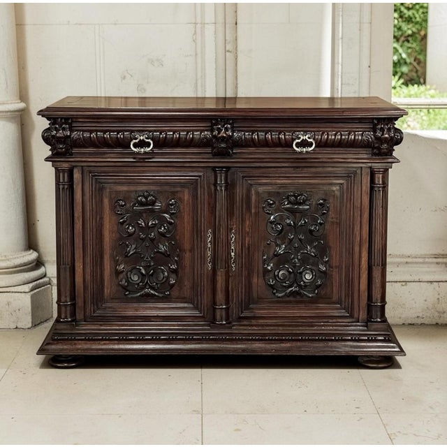 A 19th century French Renaissance Revival buffet hand carved from rich walnut, glowing with a deep, warm patina that only...