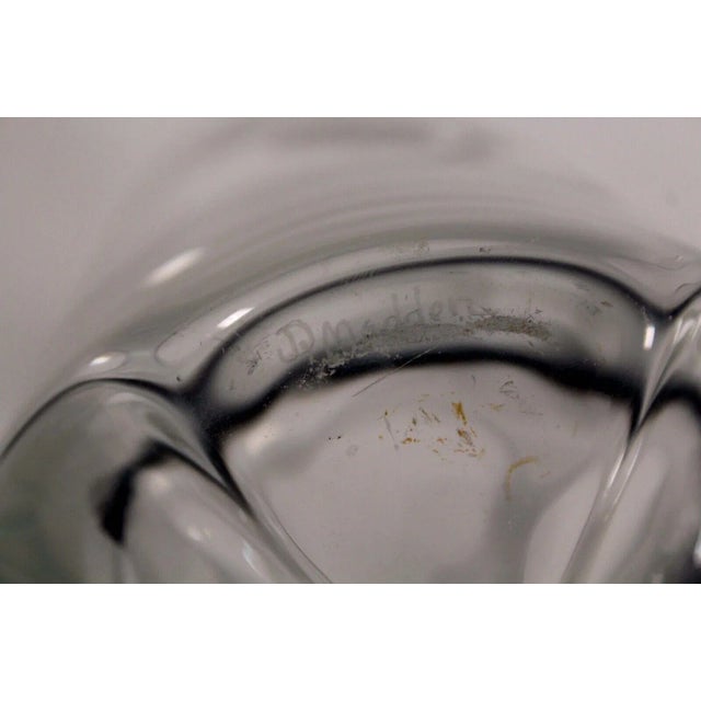 An exquisite ornamental glass vessel with etched design. Signature D. Madden on the bottom. The vase features a female...