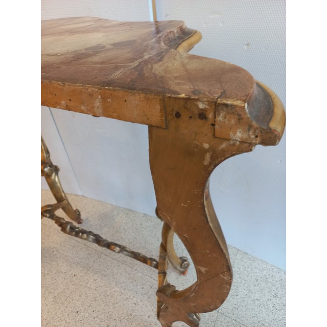 Console made in the Louis Philippe period in the Italian area. Entirely gilded, marbled top, in good condition, with age-...