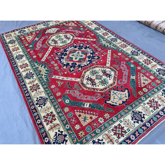 This bold Karachov Kazak rug features three large octagonal medallions stacked vertically on ivory grounds, each centered...