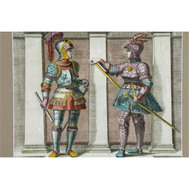 A pair of colored engravings framed behind glass depicting Ramprechtus and Hetoprechtus in suits of armor to one and...
