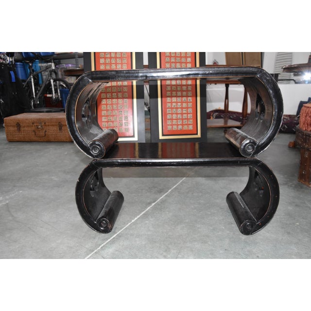 Striking pair of low wooden stands featuring a sleek, curved silhouette and rich dark finish. These sculptural pieces have...