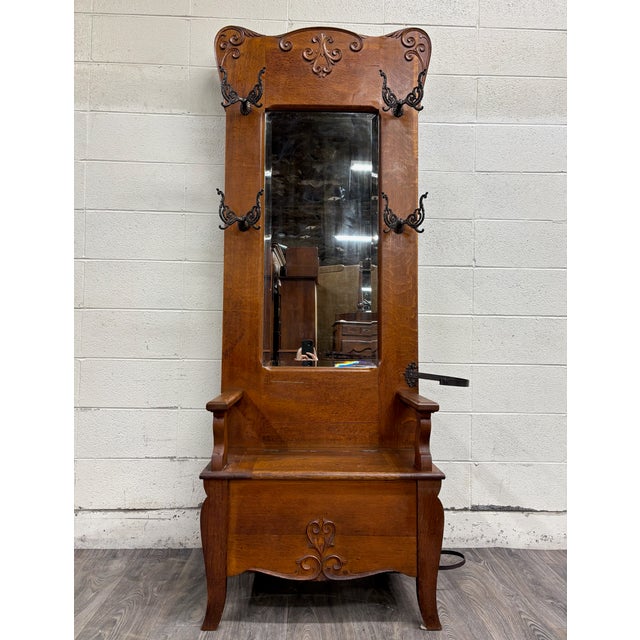 This is an absolutely stunning antique Victorian carved tiger oak hall tree with carved crest, four butterfly hooks (with...