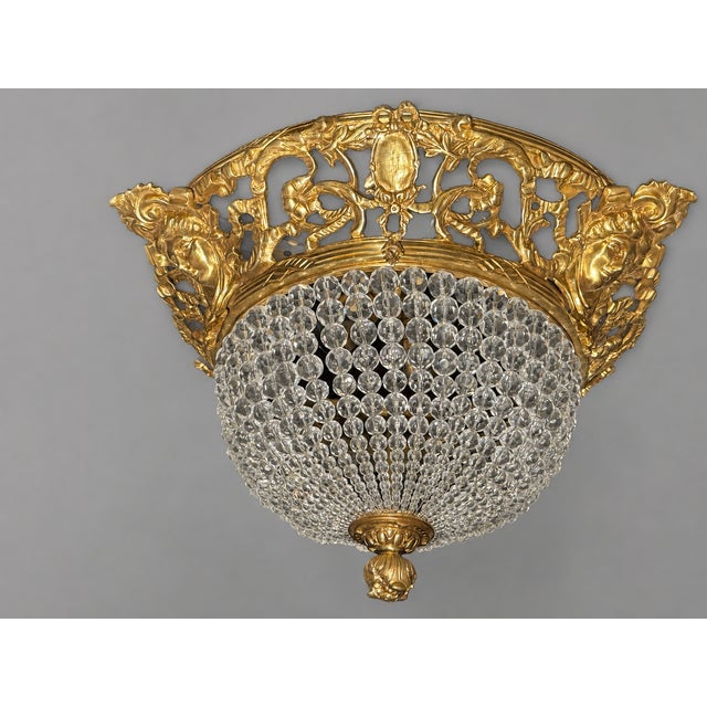 A richly decorative 1970s Baroque Revival ceiling lamp, crafted in solid bronze with crystal accents and finished in a...