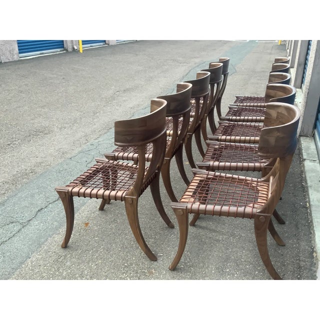 Klismos solid walnut dining chairs. The chairs are made of solid walnut with a satin finish and leather cording. The...