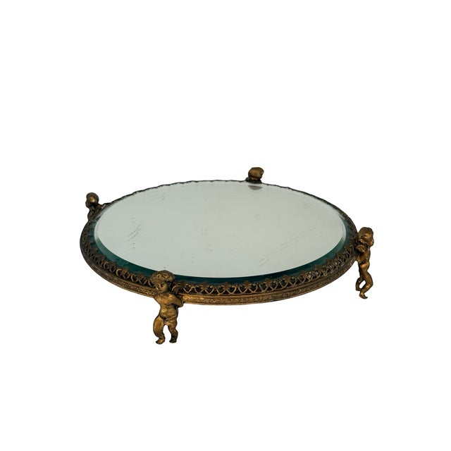 A magnificent and rare antique French mirrored plateau tray supported by four exquisite figural putti (cherub) standing...