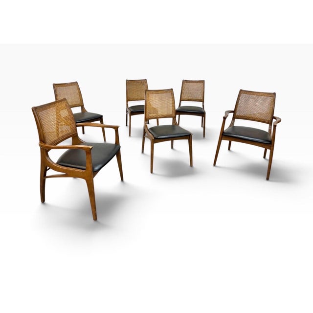 A stylish set of six Mid-Century Modern walnut dining chairs, dating to the 1960s, featuring beautifully shaped frames and...