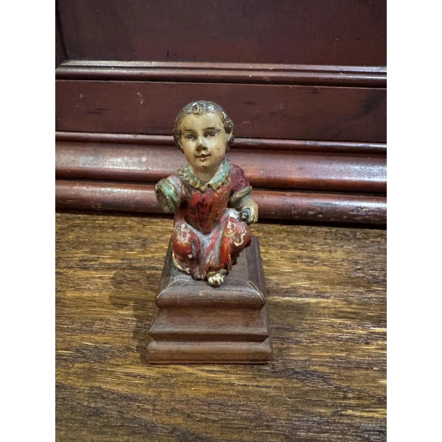 This 18th century polychromed wooden Santos depicts the Christ Child holding a sparrow in one hand. He is missing the...