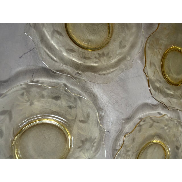 A beautiful set of four vintage amber depression glass plates, each featuring an elegant etched floral star and leaf motif...