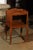 A French Louis XV style 19th century wooden bedside table with three-quarter gallery, open shelf and cabriole legs. This...