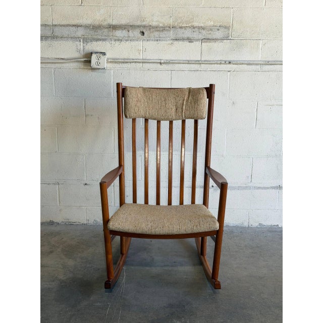 This striking rocking armchair features a tall spindle back and sweeping curved armrests. The elegant silhouette showcases...