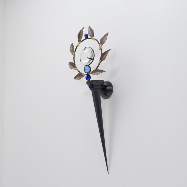 An "Olympia" wall sconce by Mark Brazier-Jones, forged from iron with a copper sheet laurel garland and glass accents,...