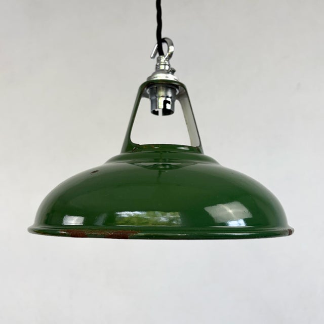 A classic industrial pendant by Coolicon, with a wide domed shade in deep green vitreous enamel and a bright white enamel...